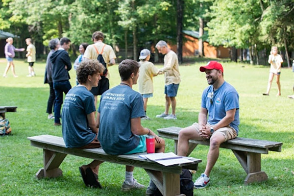 A man talking with two college boys